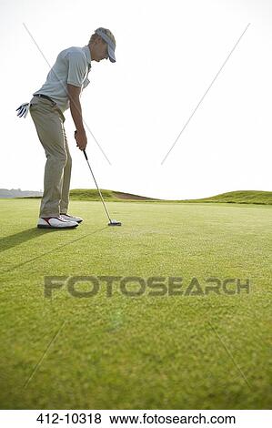 Man putting on golf course View Large Photo Image Stock Photo - Man putting on golf course. Fotosearch