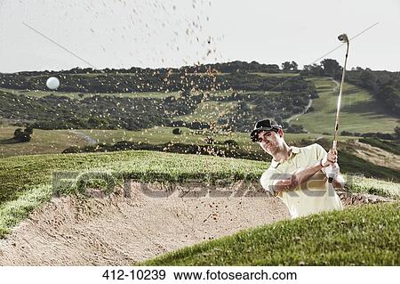 Man swinging from sand trap on golf course View Large Photo Image Stock Photo - Man swinging from sand trap on golf course. Fotosearch