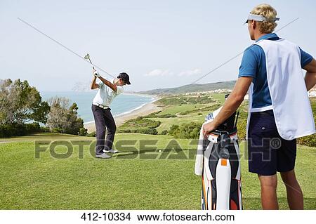 Picture - Men playing golf on course. Fotosearch