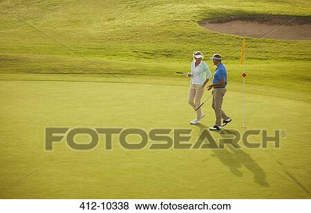 Senior couple walking on golf course View Large Photo Image Stock Photo - Senior couple walking on golf course. Fotosearch