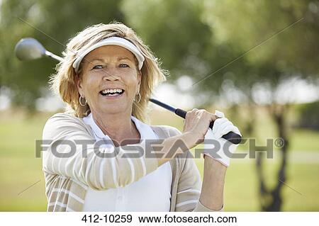 Senior woman playing golf on course View Large Photo Image Stock Photo - Senior woman playing golf on course. Fotosearch