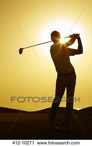 Stock Image - Silhouette of man swinging golf club. Fotosearch