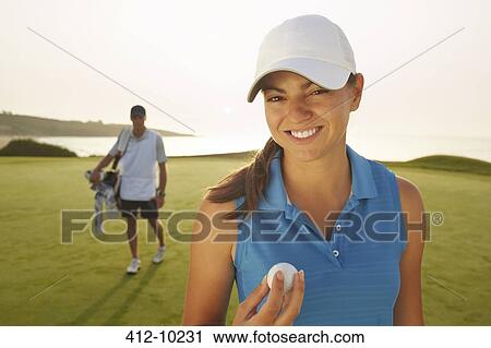 Woman holding golf ball on course View Large Photo Image Stock Image - Woman holding golf ball on course. Fotosearch
