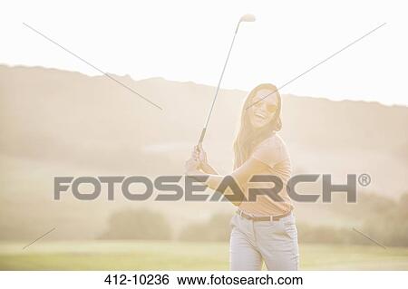 Woman playing golf on course View Large Photo Image Stock Photograph - Woman playing golf on course. Fotosearch