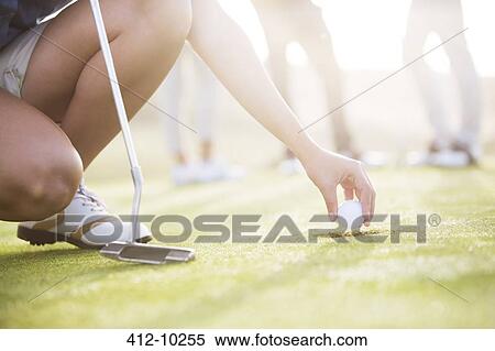 Woman removing golf ball from hole View Large Photo Image Stock Photography - Woman removing golf ball from hole. Fotosearch