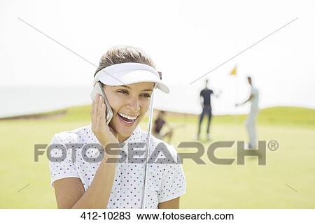 Woman talking on cell phone on golf course View Large Photo Image Stock Image - Woman talking on cell phone on golf course. Fotosearch