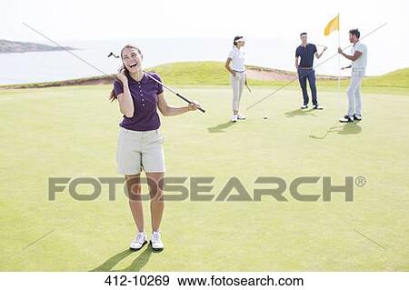 Woman talking on cell phone on golf course View Large Photo Image Stock Photo - Woman talking on cell phone on golf course. Fotosearch