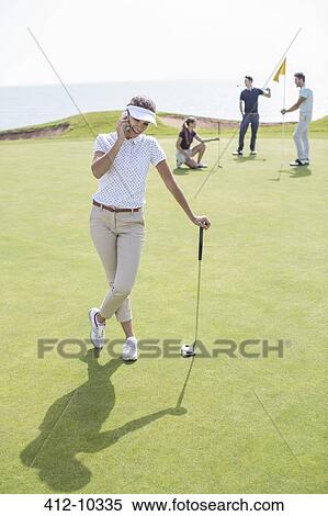 Woman talking on cell phone on golf course View Large Photo Image Stock Photography - Woman talking on cell phone on golf course. Fotosearch