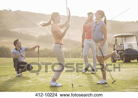 Women high fiving on golf course View Large Photo Image Picture - Women high fiving on golf course. Fotosearch