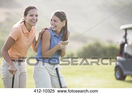 Stock Photography - Women laughing on golf course. Fotosearch