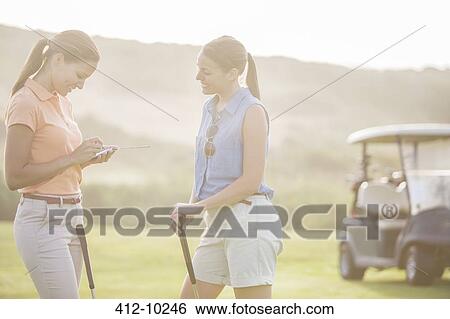 Stock Photograph - Women playing golf on course. Fotosearch