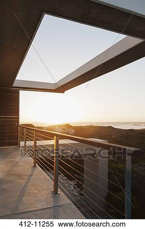 Balcony of modern house overlooking ocean at sunset View Large Photo Image Stock Photography - Balcony of modern house overlooking ocean at sunset. Fotosearch
