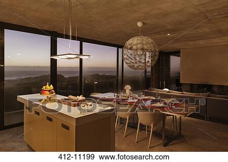 Breakfast bar and dining table in modern kitchen overlooking ocean at dusk View Large Photo Image Stock Photo - Breakfast bar and dining table in modern kitchen overlooking ocean at dusk. Fotosearch