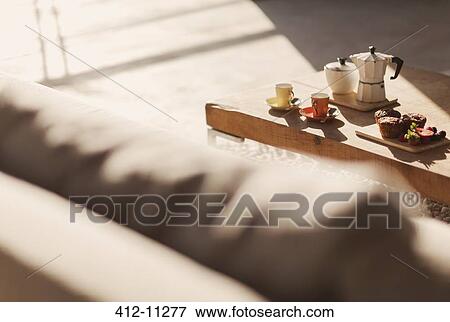 Stock Photo - Breakfast on coffee table in living room. Fotosearch