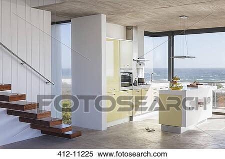 Stock Photography - Floating staircase and modern kitchen overlooking ocean. Fotosearch