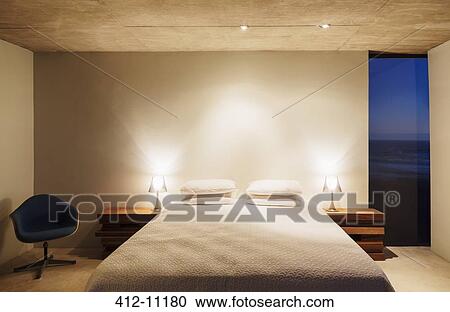 Illuminated lamps and bed in modern bedroom View Large Photo Image Stock Image - Illuminated lamps and bed in modern bedroom. Fotosearch
