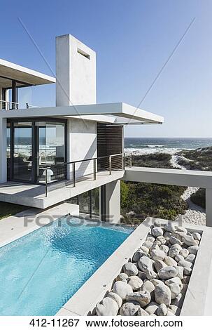 Stock Photo - Lap pool and balcony of modern house overlooking ocean. Fotosearch