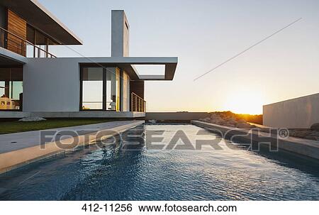 Lap pool outside modern house at sunset View Large Photo Image Stock Photograph - Lap pool outside modern house at sunset. Fotosearch