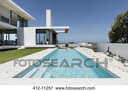 Lap pool outside modern house View Large Photo Image Stock Photo - Lap pool outside modern house. Fotosearch