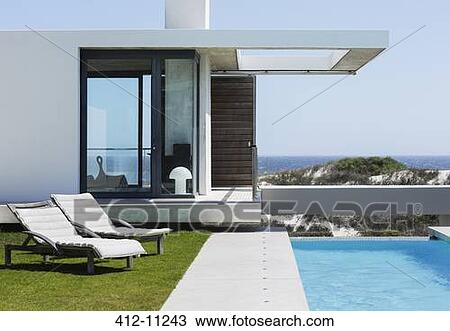 Lounge chairs and lap pool outside modern house overlooking ocean View Large Photo Image Stock Image - Lounge chairs and lap pool outside modern house overlooking ocean. Fotosearch