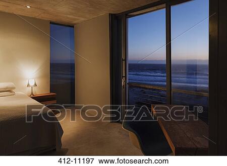 Modern bedroom overlooking ocean at dusk View Large Photo Image Stock Photo - Modern bedroom overlooking ocean at dusk. Fotosearch