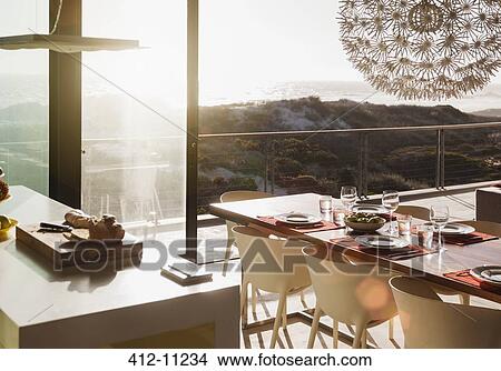 Picture - Modern dining room overlooking ocean at sunset. Fotosearch