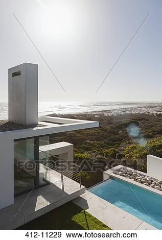 Modern house and lap pool overlooking ocean View Large Photo Image Stock Photo - Modern house and lap pool overlooking ocean. Fotosearch