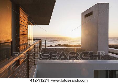 Modern house overlooking ocean at sunset View Large Photo Image Picture - Modern house overlooking ocean at sunset. Fotosearch