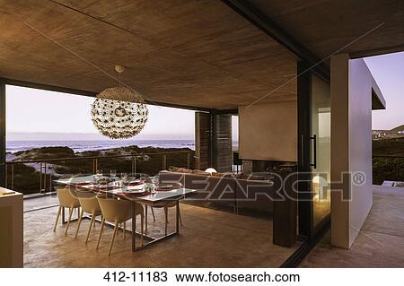 Stock Image - Modern house overlooking ocean at sunset. Fotosearch