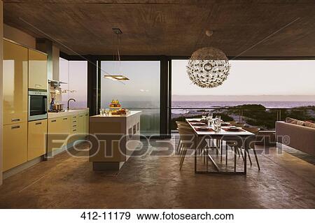 Modern kitchen and dining room overlooking ocean at sunset View Large Photo Image Stock Photo - Modern kitchen and dining room overlooking ocean at sunset. Fotosearch