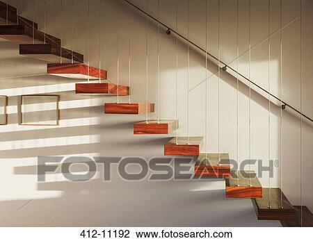 Stock Image - Shadows on floating staircase in modern house. Fotosearch
