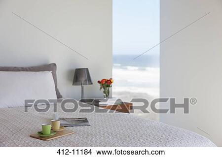 Tray with espresso cups on bed in bedroom with ocean view View Large Photo Image Picture - Tray with espresso cups on bed in bedroom with ocean view. Fotosearch