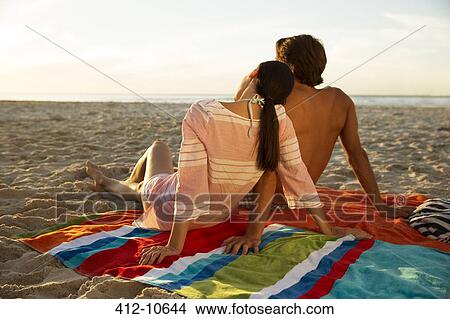 Picture - Couple relaxing together on beach. Fotosearch