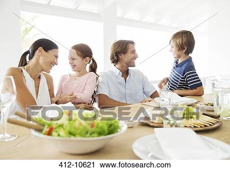 Family eating together at table View Large Photo Image Stock Image - Family eating together at table. Fotosearch