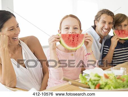 Family eating watermelon at table View Large Photo Image Stock Photograph - Family eating watermelon at table. Fotosearch