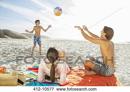 Stock Photo - Family playing together on beach. Fotosearch