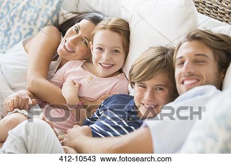 Family relaxing together on sofa View Large Photo Image Stock Image - Family relaxing together on sofa. Fotosearch