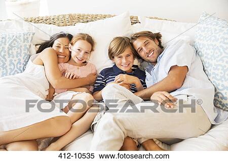 Family relaxing together on sofa View Large Photo Image Stock Photography - Family relaxing together on sofa. Fotosearch