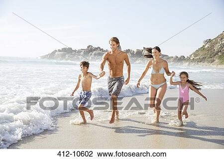 Stock Image - Family running together in waves. Fotosearch