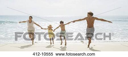 Stock Photography - Family running together on beach. Fotosearch