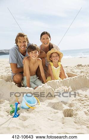 Family sitting in sandcastle on beach View Large Photo Image Stock Image - Family sitting in sandcastle on beach. Fotosearch