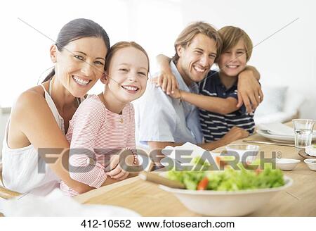 Family sitting together at table View Large Photo Image Stock Image - Family sitting together at table. Fotosearch