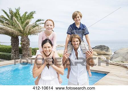 Picture - Family smiling by swimming pool. Fotosearch