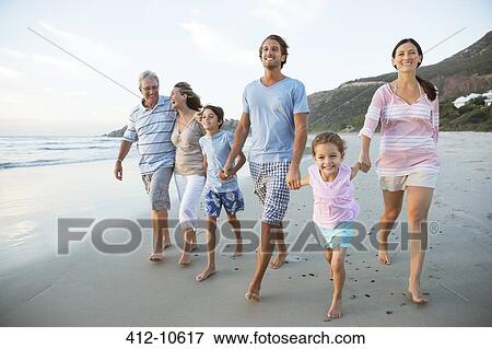 Stock Photo - Family walking together on beach. Fotosearch