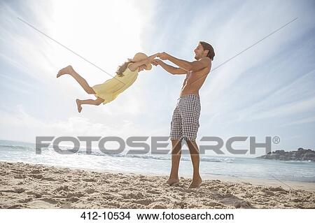 Picture - Father and daughter playing on beach. Fotosearch