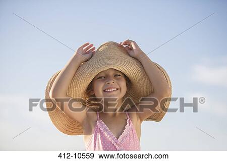Stock Photo - Girl wearing sun hat outdoors. Fotosearch