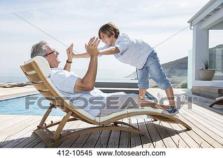 Grandfather and grandson playing at poolside View Large Photo Image Stock Photography - Grandfather and grandson playing at poolside. Fotosearch