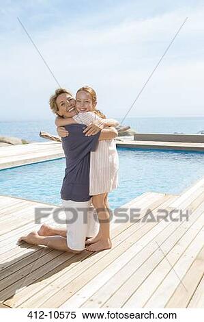 Grandmother hugging granddaughter at poolside View Large Photo Image Stock Photography - Grandmother hugging granddaughter at poolside. Fotosearch