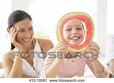 Stock Image - Mother and daughter playing with food. Fotosearch