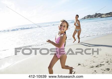 Stock Photo - Mother and daughter running on beach. Fotosearch
